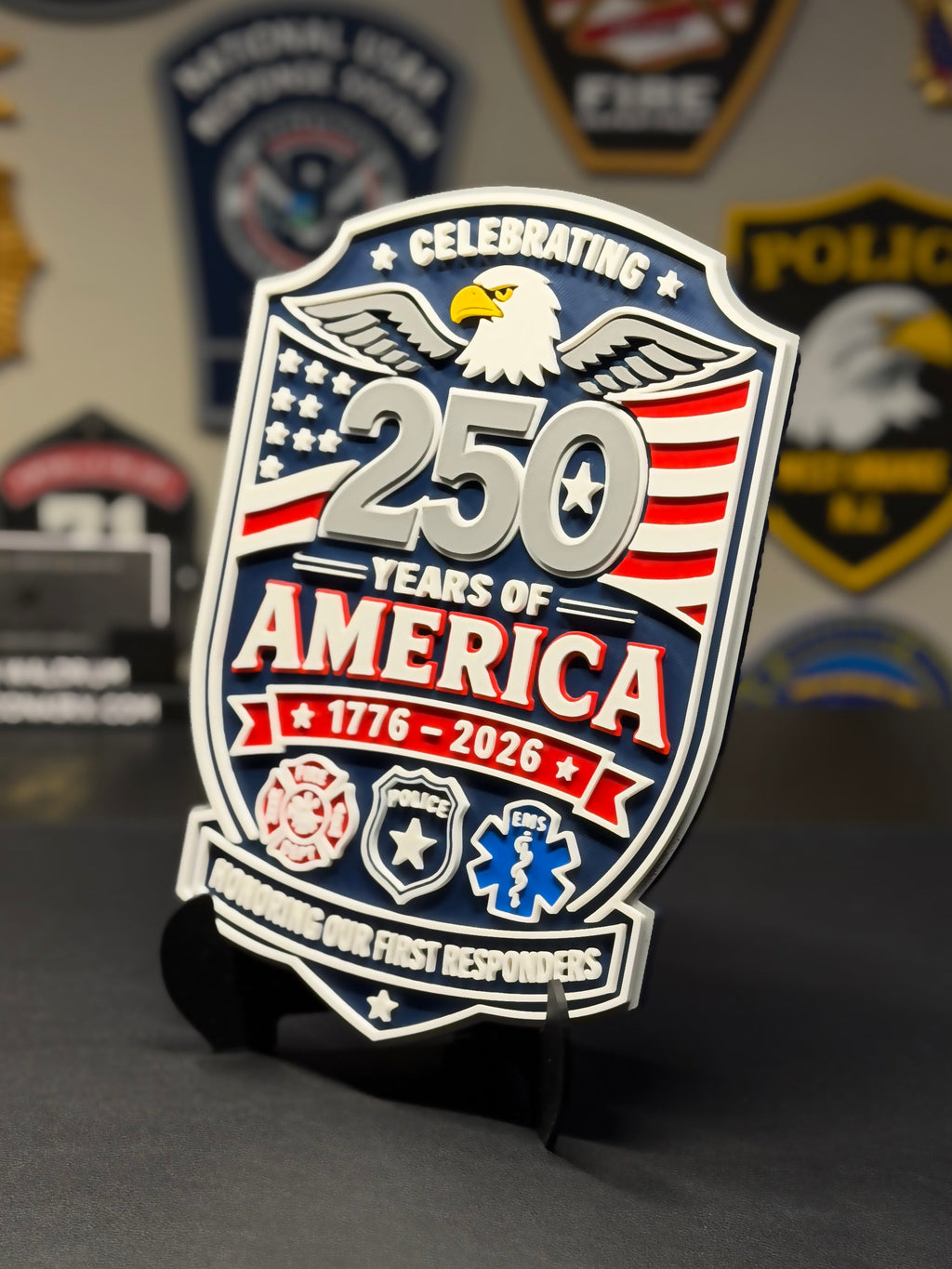 Decorative plaque celebrating 250 years of America with an eagle and American flag design, placed on a dark surface with other decorative items in the background.